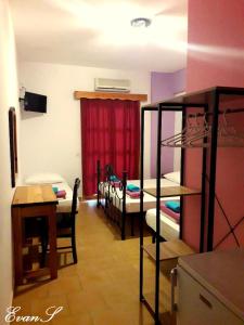 Zimmer mit einem Zimmer mit Etagenbetten und einem Tisch in der Unterkunft EVANS Skiathos in Skiathos-Stadt