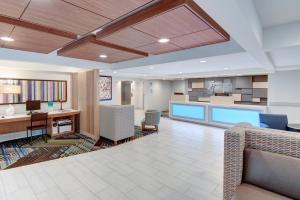 an office lobby with a desk and a kitchen at Holiday Inn Express & Suites West Long Branch - Eatontown, an IHG Hotel in West Long Branch