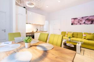 a kitchen and dining room with a wooden table and green chairs at Apartments Fiorello in Rijeka +40 photos