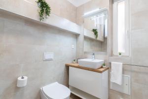 a bathroom with a white sink and a toilet at Apartments Fiorello in Rijeka