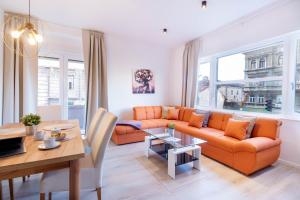 a living room with an orange couch and a table at Apartments Fiorello in Rijeka