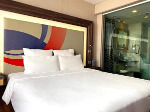 a bedroom with a large white bed and a shower at Novotel Bangkok IMPACT in Nonthaburi