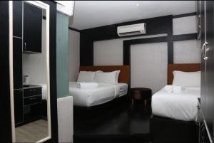a hotel room with two beds and a mirror at Vivids Hotel in Kuala Lumpur