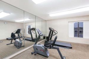 een fitnessruimte met loopbanden en crosstrainers voor een spiegel bij Super 8 by Wyndham Jacksonville AR in Jacksonville