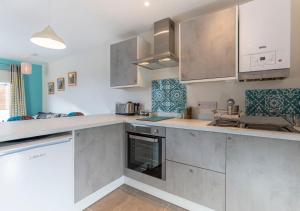 a kitchen with stainless steel cabinets and appliances at Stones Throw Studio Apartment Bude Cornwall in Bude