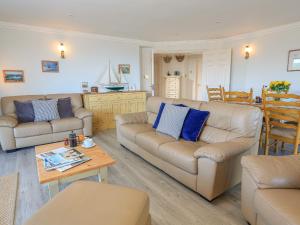 a living room with two couches and a table at 7 Thurlestone Rock in Kingsbridge