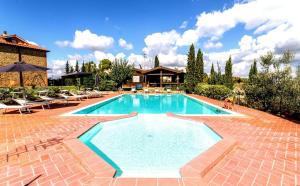 una gran piscina con sillas y una casa en Calanchi Apartments, en Montaione