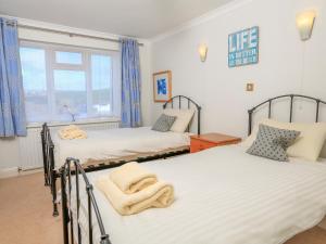 two twin beds in a room with a window at 7 Thurlestone Rock in Kingsbridge +21 photos