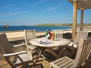 a wooden table with two chairs and two bottles of wine at 7 Thurlestone Rock in Kingsbridge