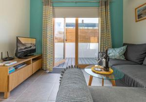 a living room with a couch and a television at Stones Throw Studio Apartment Bude Cornwall in Bude