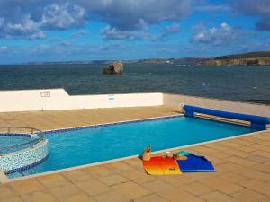 a swimming pool next to a body of water at 7 Thurlestone Rock in Kingsbridge