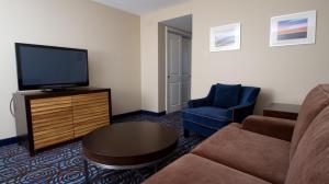 a living room with a couch and a flat screen tv at Ocean Club Hotel in Cape May