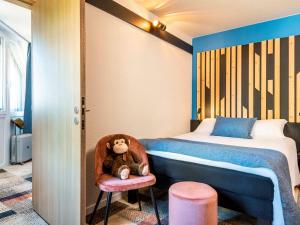 een slaapkamer met een bed en een teddybeer in een stoel bij ibis Styles Boulogne sur Mer Centre Cathédrale in Boulogne-sur-Mer