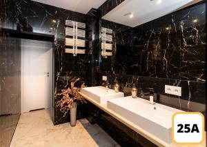 华沙Sienna 41 Boutique Warsaw Apartments的浴室设有两个水槽和黑色大理石墙壁。 更多37张照片