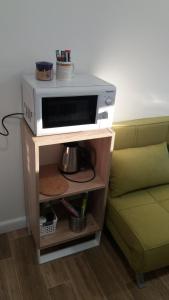 een magnetron op een standaard naast een bank bij Single Suite Apartment in Timişoara