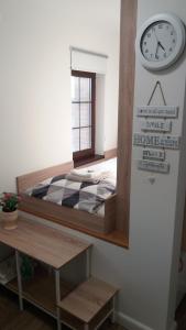 een slaapkamer met een bed en een klok aan de muur bij Single Suite Apartment in Timişoara +13 foto's