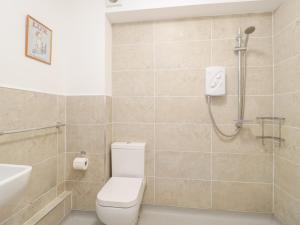 a bathroom with a shower and a toilet and a sink at 14 Lyme Mews in Seaton +17 photos