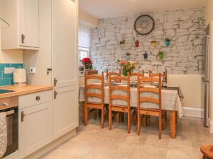 een keuken en eetkamer met een tafel en stoelen bij Happy Feet Cottage in Bradwell