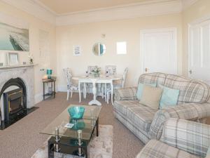 a living room with a couch and a table at Llys Madoc, First Floor Flat in Penmaen-mawr