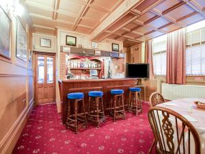 eine Küche mit einer Bar mit blauen Stühlen in der Unterkunft OYO The Rowers Hotel, Dunston Gateshead in Newcastle upon Tyne