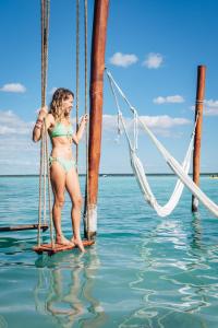 a woman in a bikini standing on a boat at Blue Bird in Bacalar