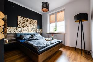a bedroom with a bed with a black accent wall at Blue House Warsaw Center in Warsaw