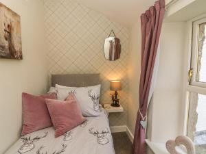 una camera da letto con letto, cuscini e finestra di Bank End Cottage a Carnforth