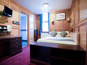 Schlafzimmer mit einem Bett, einem Schreibtisch und einem TV in der Unterkunft OYO The Rowers Hotel, Dunston Gateshead in Newcastle upon Tyne