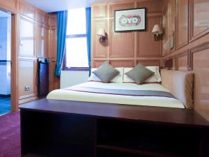 Schlafzimmer mit einem großen Bett mit einem Kopfteil aus Holz in der Unterkunft OYO The Rowers Hotel, Dunston Gateshead in Newcastle upon Tyne