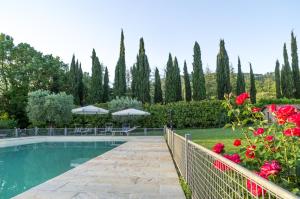 a swimming pool with a fence and red roses at Borgo Benedetto in Sansepolcro