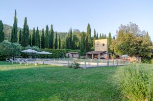 a park with benches and a building and trees at Borgo Benedetto in Sansepolcro