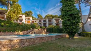 eine Villa mit einem Pool und einem Baum in der Unterkunft Cliper A3 in Llafranc