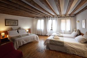 Habitación grande con 2 camas y sofá en San Giacomo Venezia, en Venecia