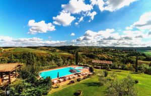 an overhead view of a swimming pool in a green field at Calanchi Apartments in Montaione