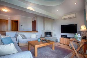 a living room with a couch and a tv at Marina View Luxury Home in Gouvia