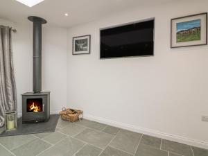 a living room with a fireplace and a flat screen tv at The Bull Pen in St Austell
