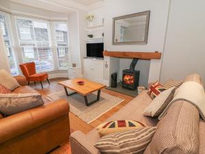 a living room with a couch and a fireplace at Little Herdwick in Windermere
