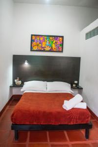 a bedroom with a large bed with a red blanket at Ulucaho Hostel in Bogotá