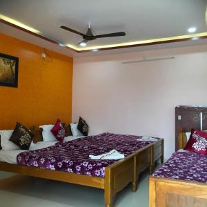 a bedroom with two beds and a ceiling at Jayaram Residency Srikalahasti in Srikalahasti