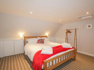 a bedroom with a large bed with a red blanket at 28 Low Shore in Banff