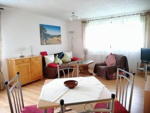 sala de estar con mesa y sofá en Ferienwohnung Am Apelsberg en Neuhaus am Rennweg