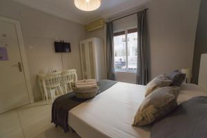 Schlafzimmer mit einem großen weißen Bett und einem Fenster in der Unterkunft Old Town Alicante in Alicante