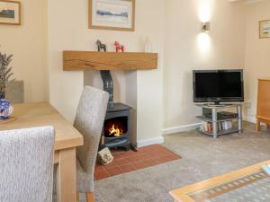 a living room with a fireplace and a television at Lavender Cottage in Ilkeston