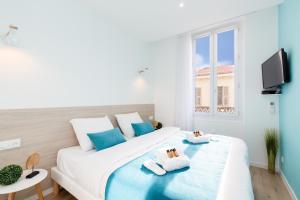 a bedroom with a large bed with towels on it at L'Albion YourHostHelper in Cannes