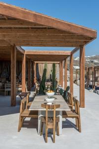 a wooden pavilion with a table and chairs at Rocabella Mykonos Hotel in Agios Stefanos