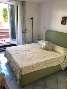 a bed in a bedroom with a large window at Elegante Villa al centro di Ischia Porto in Ischia