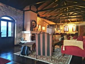 a living room with a fireplace and red chairs at Levantes Mansion in Karitaina