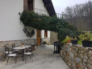 un patio avec une table et des chaises à côté d'un bâtiment dans l'établissement CASA RURAL Arriaran, à Leitza