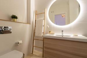 a bathroom with a sink and a mirror at MuMu Luxury Suite Lirio by Valcambre in Seville
