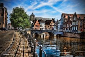 un puente sobre un río en una ciudad con edificios en Duplex appertement met zicht Damse vaart @ Brugge en Brujas
